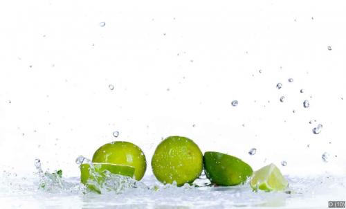 Fresh limes with water splash, isolated on white background